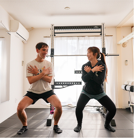 トレーナーが自重スクワットの指導をする